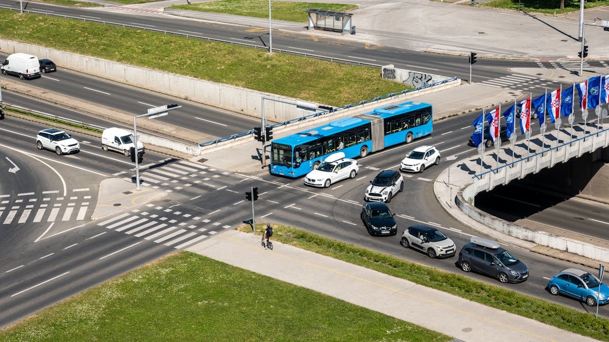 Aerial shot of a bustling traffic intersection with cars and a bus in Zagreb, Croatia.